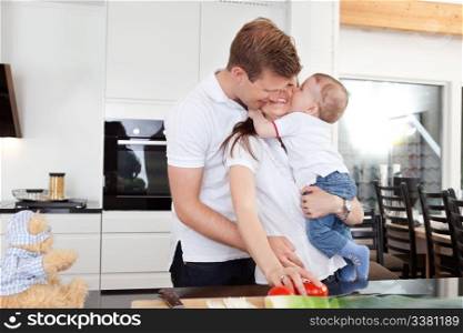 Happy family preparing a meal and getting a big hug