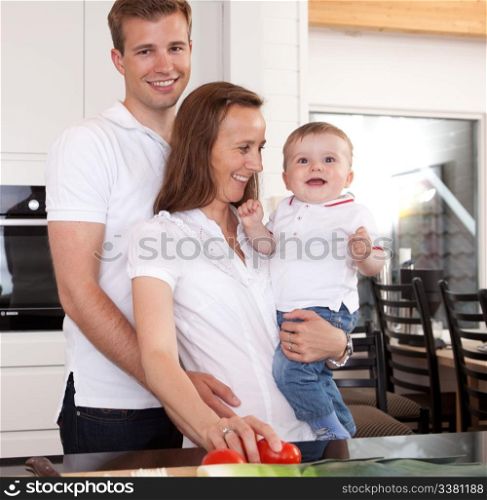 Happy family preparing meal with father giving the mother a hug
