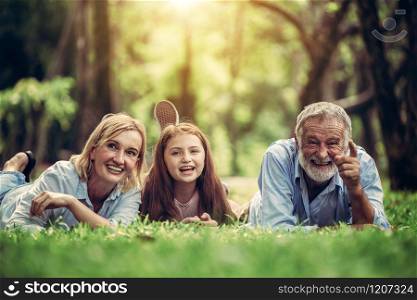 Happy family relaxing together in the park in summer. Concept of family bonding and relationship.. Happy family relaxing together in the park.