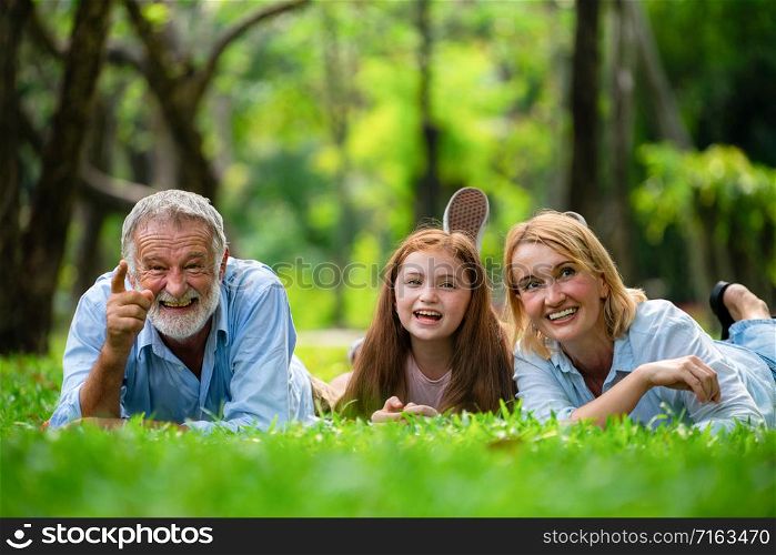 Happy family relaxing together in the park in summer. Concept of family bonding and relationship.