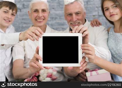 happy family showing blank screen digital tablet