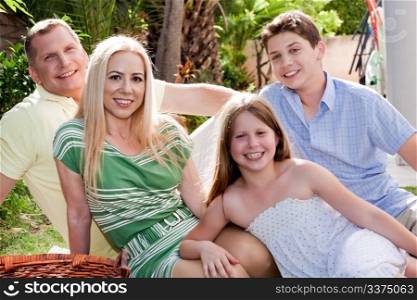 Happy family sitting and spending their lesiure time on the backyard at their home