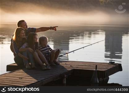 happy family sitting on the pier of the Dnieper River on the Sunset