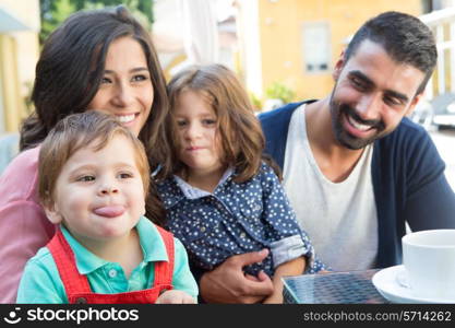 Happy family sitting together close to the pool