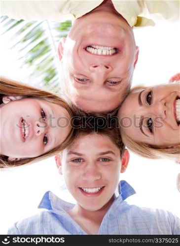 Happy family smiling and joining their heads together and looking at the camera