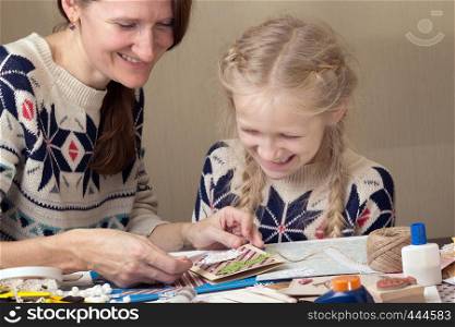 happy family - smiling Mom and daughter make a New Year's card, scrapbook