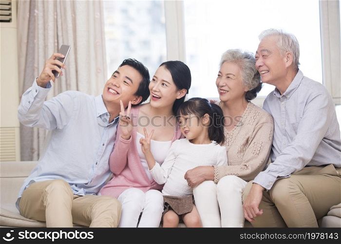 Happy family taking selfies on their phone together