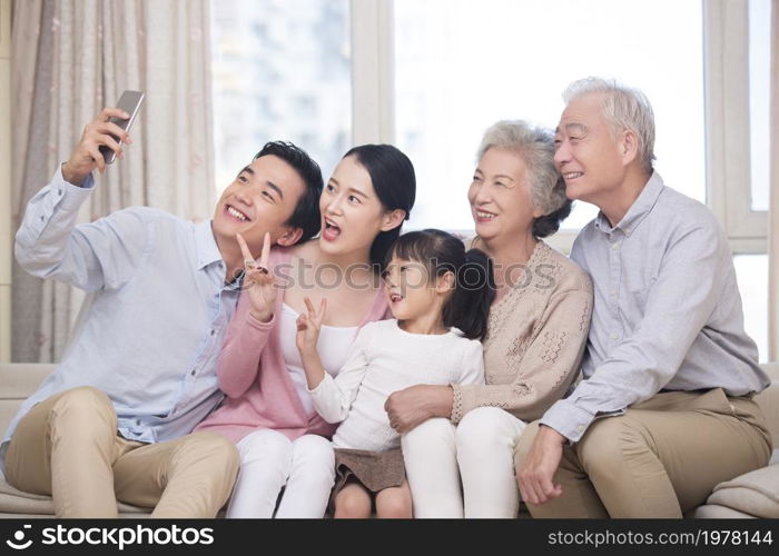 Happy family taking selfies on their phone together