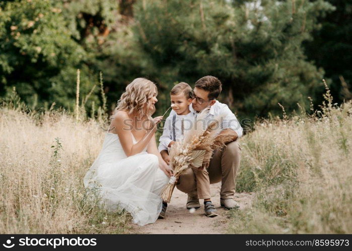 happy family three dad mom and son on a walk in the woods