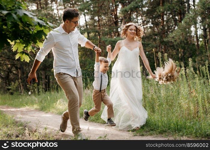 happy family three dad mom and son on a walk in the woods