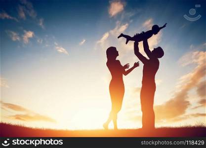 Happy family together, parents with their little child at sunset. Father raising baby up in the air.. Happy family together, parents with their little child at sunset.