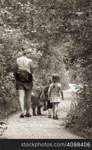 Happy family walking in a forest with their dog
