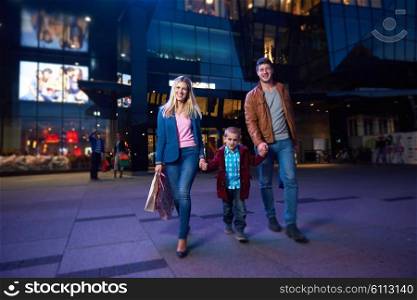 happy family walking with paper bag in front of shopping mall