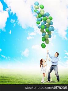 Happy family with balloons. Image of father and daughter playing with bunch of colorful balloons