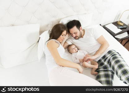 Happy family with newborn baby on the bed in the room