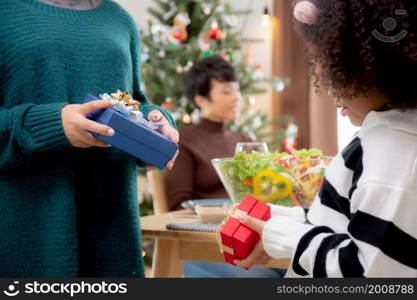 Happy family with sibling giving gift box surprising during dinner together at home, celebration in xmas with parent and children with enjoyment at house, thanksgiving eve, Merry Christmas.