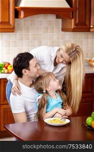 Happy family with the child in kitchen during a breakfast