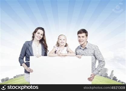 Happy family. Young happy family with white blank banner. Place for text