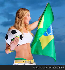 Happy fan of Brazilian football team, cheerful pretty girl on stadium cheering in support, holding up big national flag of Brazil, active people traveling to watch football games