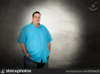 Happy fat man with blue shirt on a over gray background
