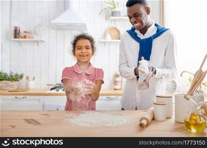 Happy father and daughter cooking cakes on breakfast. Smiling family eats on the kitchen in the morning. Dad feeds female child, good relationship. Father and daughter cooking cakes on breakfast
