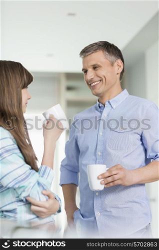 Happy father and daughter having coffee together at home
