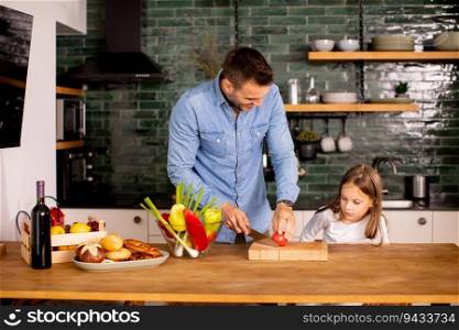 Happy father and daughter preparing vegetables in the kitchen