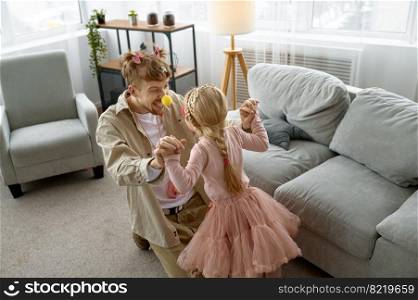 Happy father and excited little daughter having fun at home. Father and daughter wearing fairies costume having fun