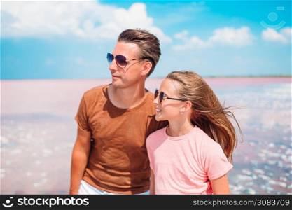 Happy father and his little daughter on the beach. Little girl and happy dad having fun during beach vacation