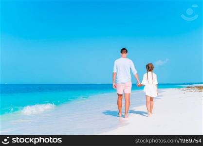 Happy father and little girl on white sandy beach have fun together. Little girl and happy dad having fun during beach vacation