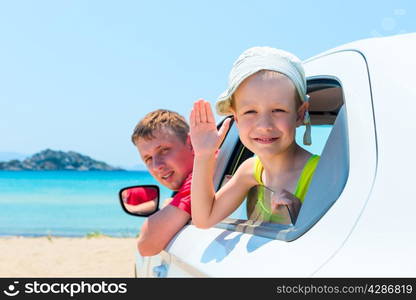 happy father and son look out of the window of the car near the sea