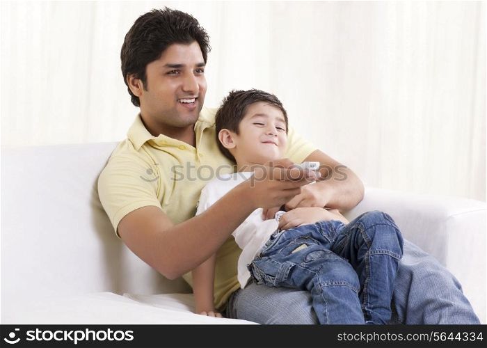Happy father and son watching television