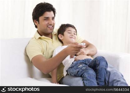 Happy father and son watching television