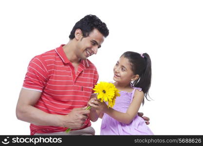 Happy father giving sunflowers to daughter over white background