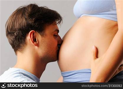 Happy father kissing his wife&acute;s belly
