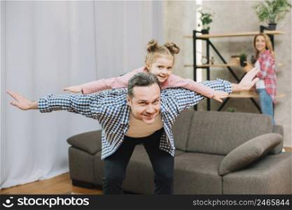 happy father piggybacking little daughter with open arms