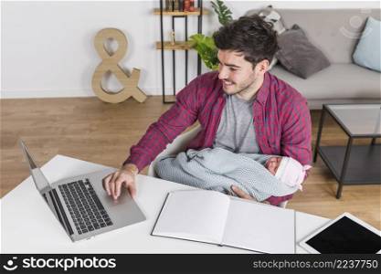 happy father with baby using laptop desk