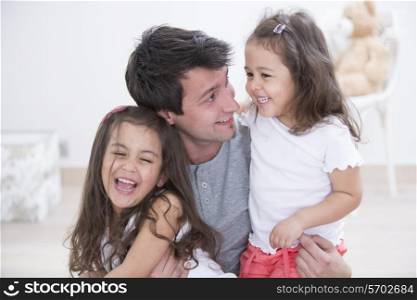 Happy father with daughters spending quality time together at home