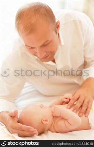 Happy father with newborn baby at home, handsome man take care about little daughter, young family, new life, love concept