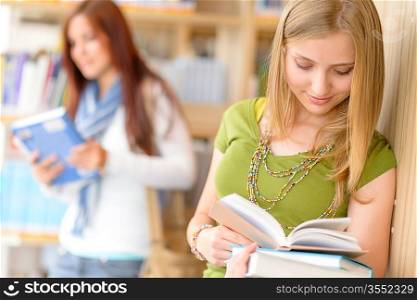 Happy female blonde student at library read books high school