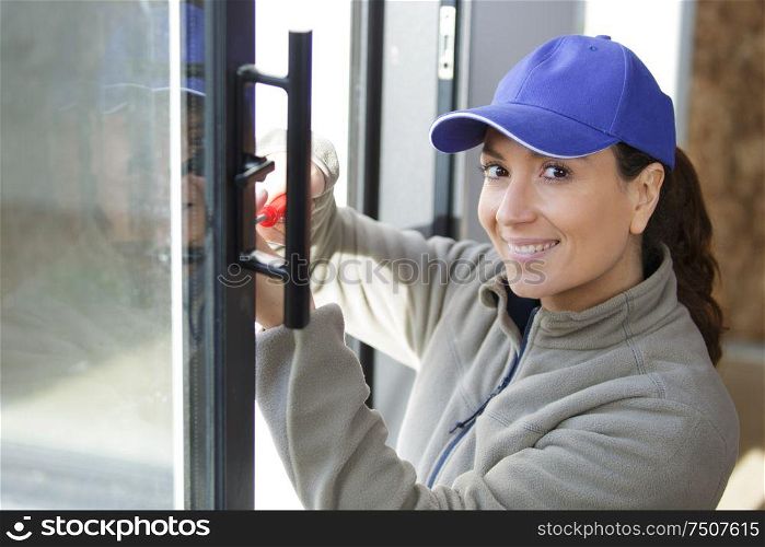 happy female builder repairs the windows