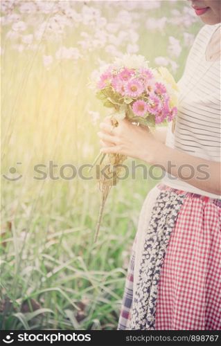 Happy female florist with bunch of colorful flower. Smiling young woman holding floral bouquet.