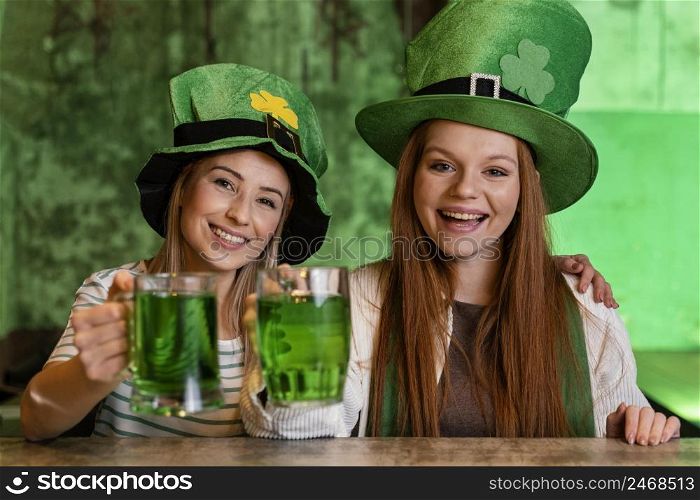 happy female friends celebrating st patrick s day together with drinks