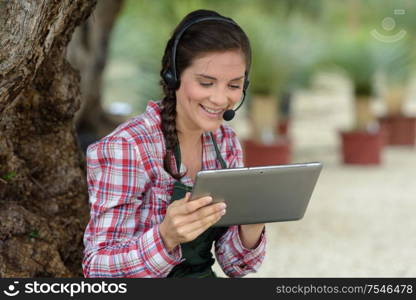 happy female garderner using a tablet outdoors