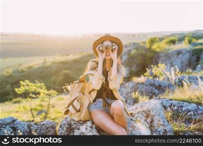 happy female hiker looking through binocular