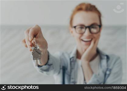 Happy female owner of new flat shows keys being glad renter or buyer. Client of real estate agency demonstrates she is houseowner. Focus on bunch of keys. Welcome to new home. Rent realty concept. Happy female owner of new flat shows keys being glad renter or buyer
