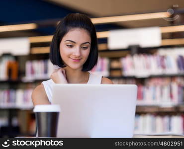 Happy female student at the library. Happy young female student sudying at the library