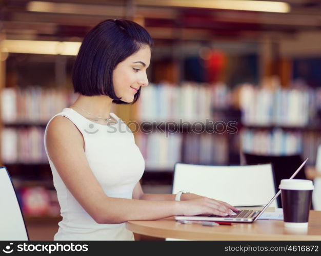 Happy female student at the library. Happy young female student sudying at the library