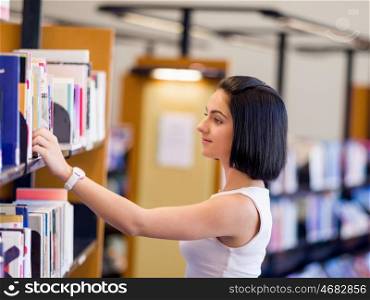 Happy female student at the library. Happy young female student sudying at the library