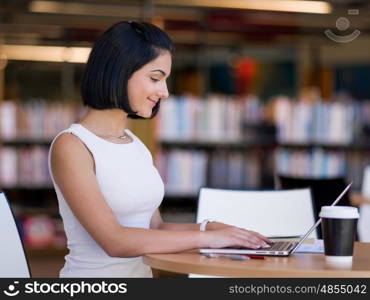 Happy female student at the library. Happy young female student sudying at the library